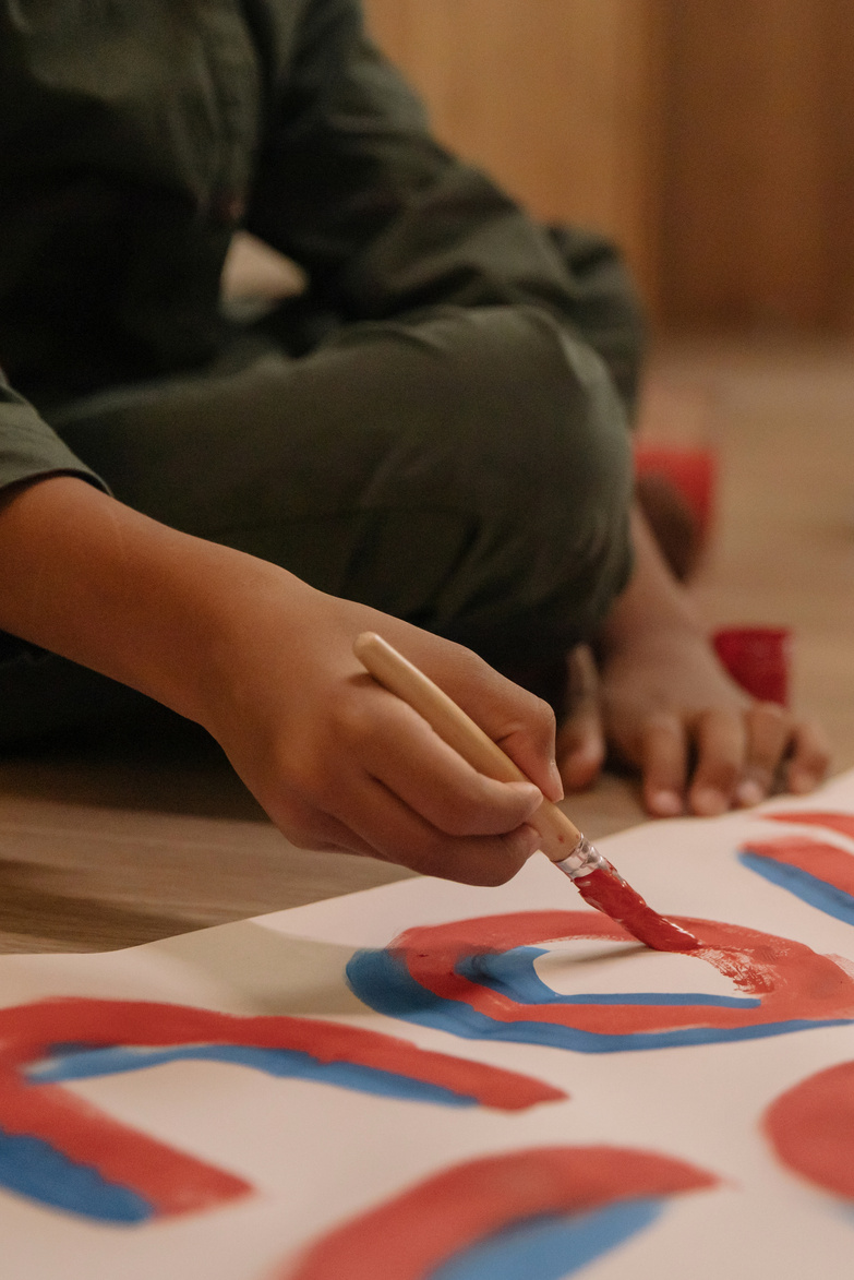 Close-Up Shot of a Person Painting a Poster